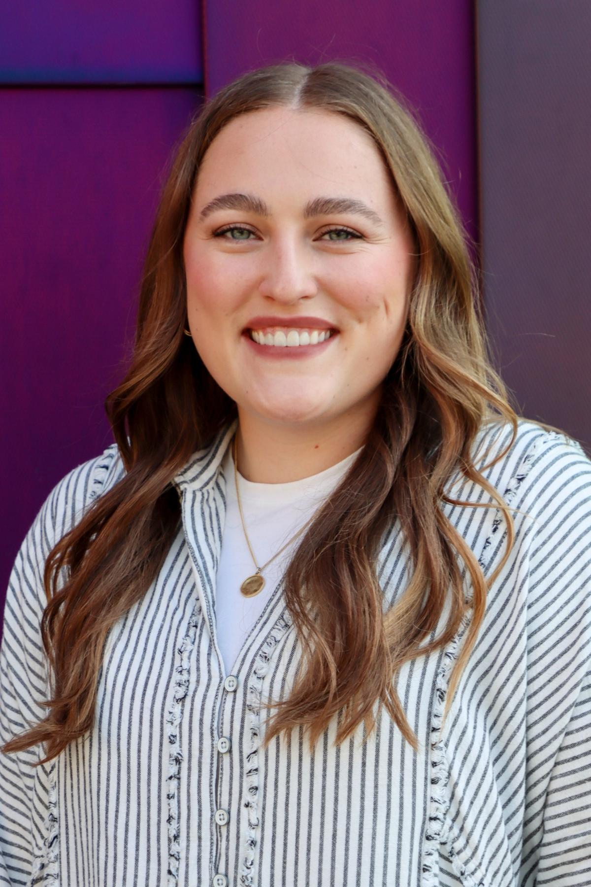 Ally Huffman with long brown hair wearing a striped blouse.