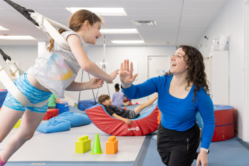Girl swinging and giving high five to brunette woman