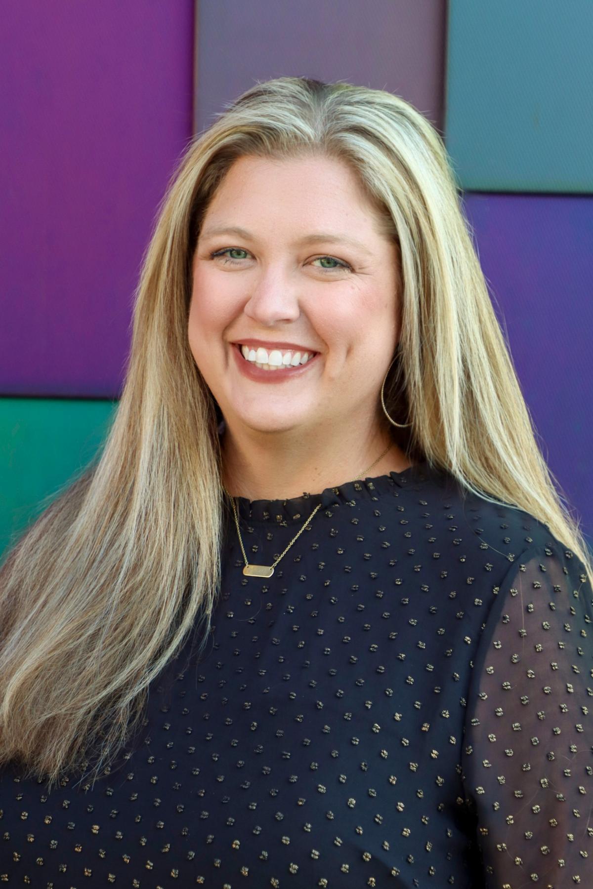 Traci Peterson, smiling woman with long blonde hair in a black blouse.