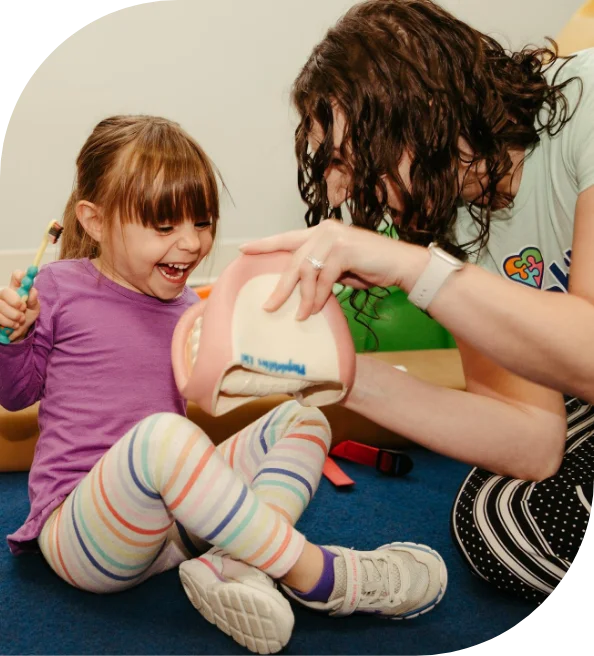 Therapist playing with a baby on a foam mat