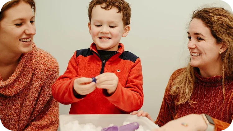 Therapist engaging in creative play with toddler